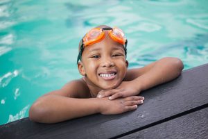 Little boy smiling in the pool at the leisure center